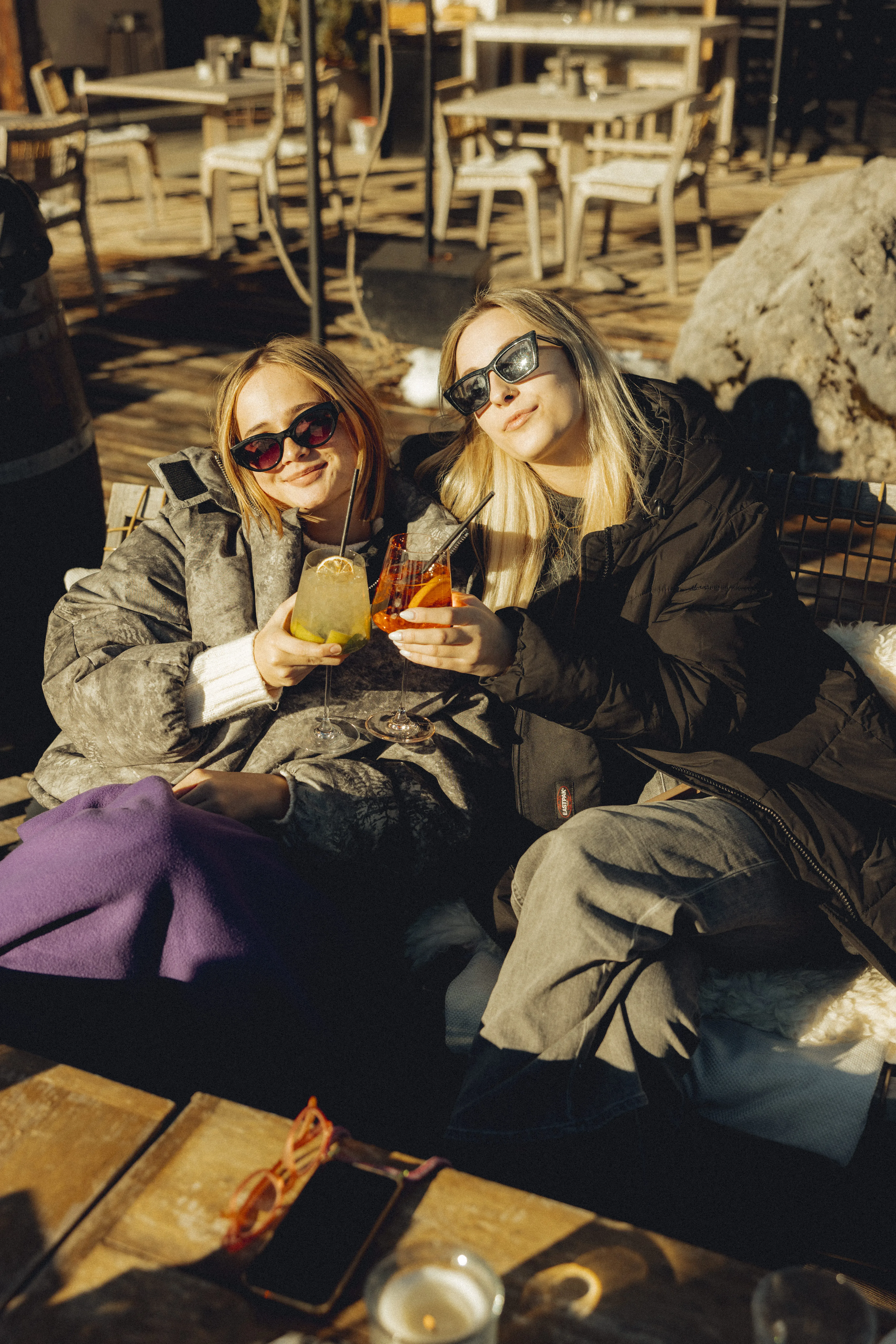 Kobiety delektują się drinkami w zimowym słońcu